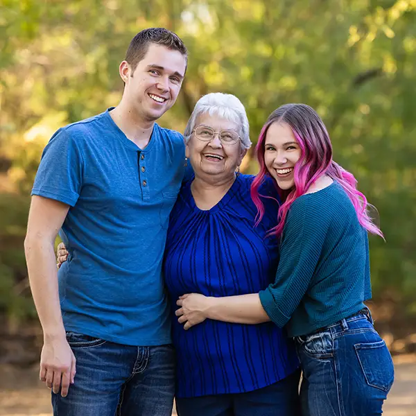 Grandmother smiling with her two adult grandchildren during a family photo session in Mesa, Arizona.