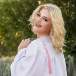 Senior girl in a white gown holding a bouquet of flowers in Queen Creek, Arizona.