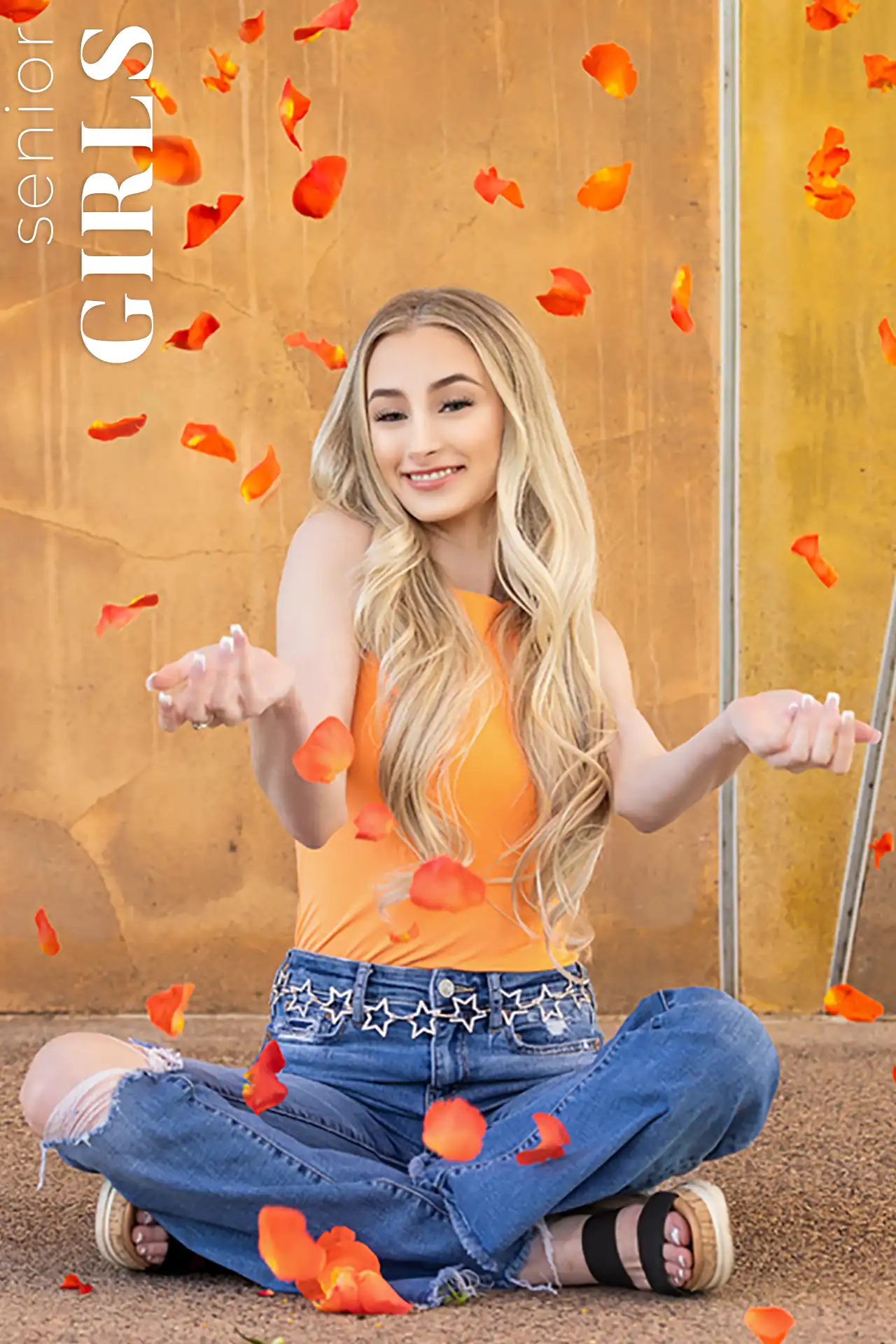 Senior girl in an orange top tossing rose petals during her senior session in Gilbert, Arizona.