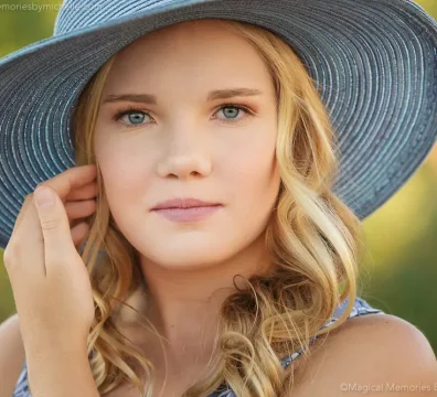 Close-up of a 13-year-old girl wearing a wide-brimmed blue hat during her birthday photo shoot.