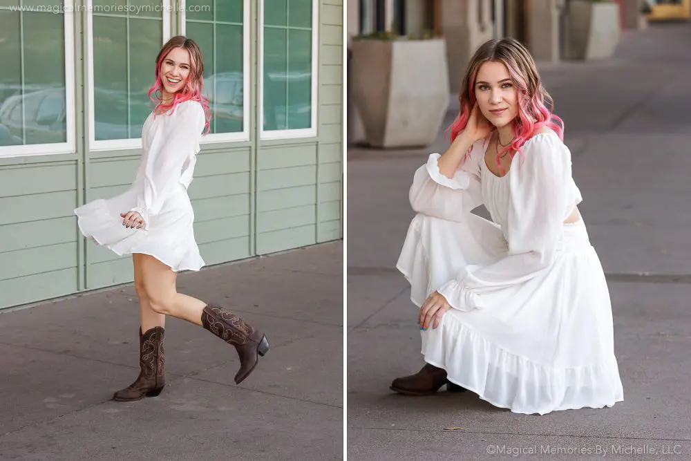 Senior girl with pink hair twirling in a white dress and boots for a playful, stylish photo on city streets.