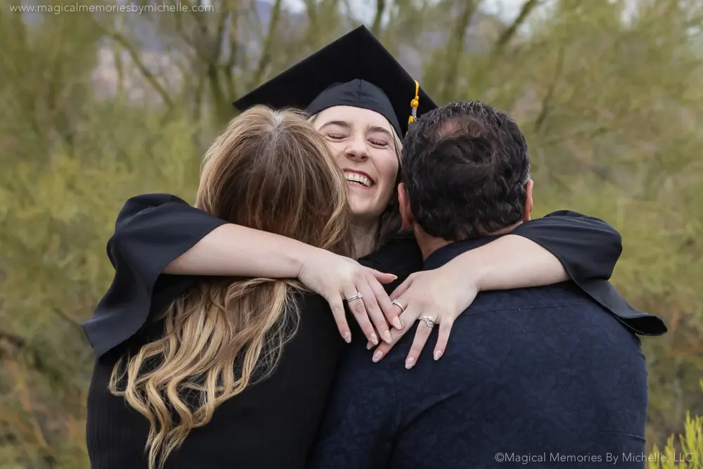Emotional moment of a senior hugging both parents in cap and gown