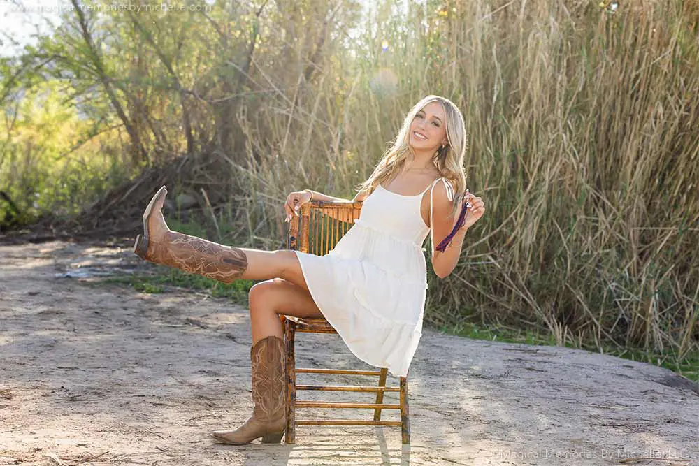Senior girl in white dress and boots smiling outdoors during a fun senior photo session in Mesa, Arizona—showing the results of planning ahead.