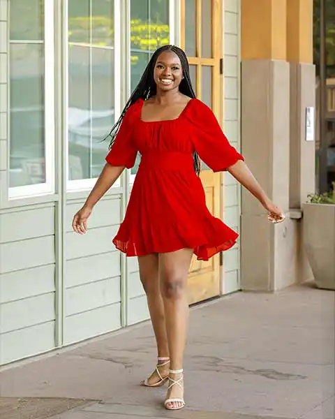 Senior girl from Williams Field High School walking in a red dress during her senior photo session in Gilbert, Arizona.