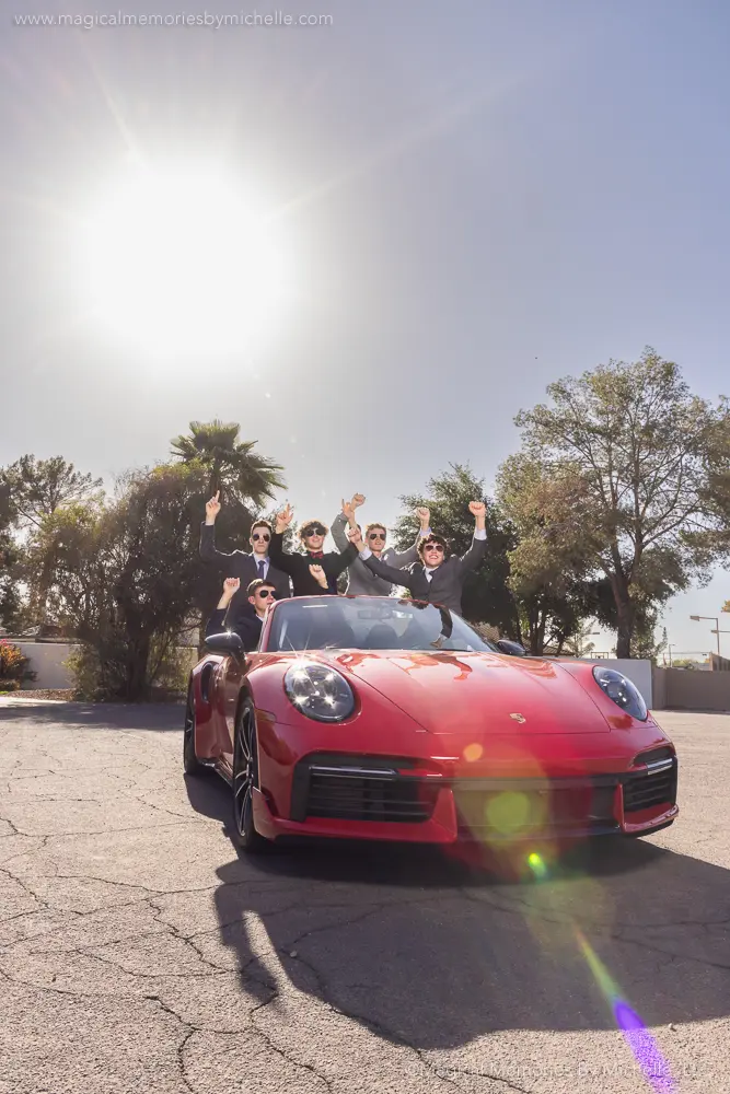 Group of senior boys celebrating in a red Porsche convertible during senior pictures in Arizona.