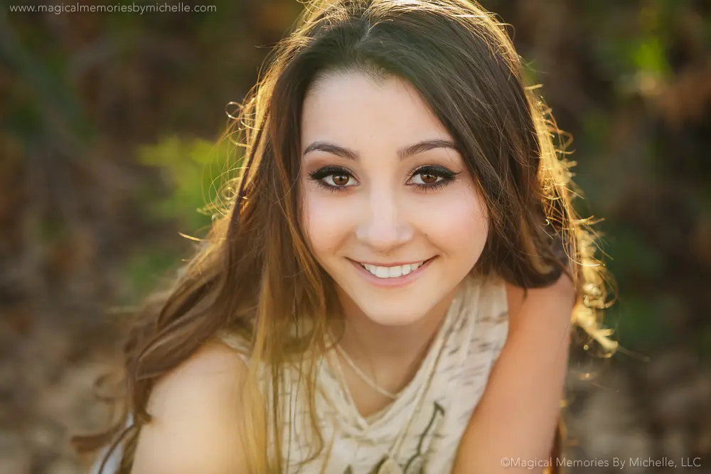 Close-up boho senior portrait in Chandler showing professional makeup with soft curls and natural sunlight.