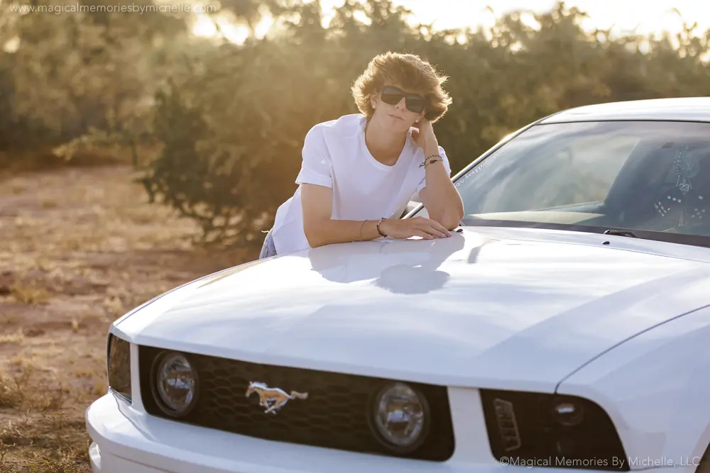 Teen leaning on white Mustang during sunset senior session in Mesa, Arizona.
