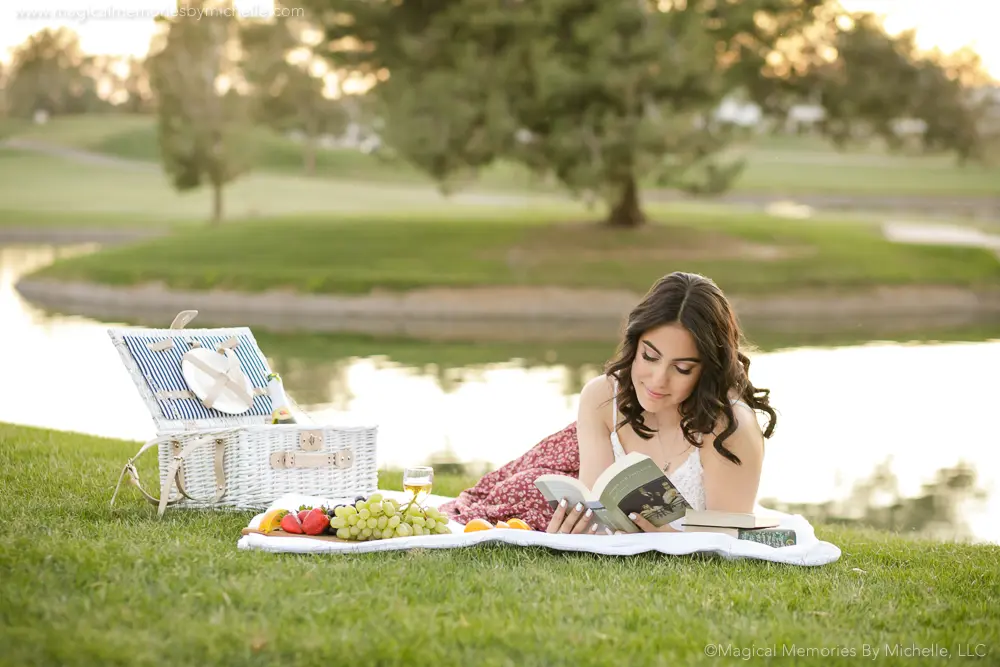 Senior girl reading a book during picnic‑style senior photos Chandler Arizona
