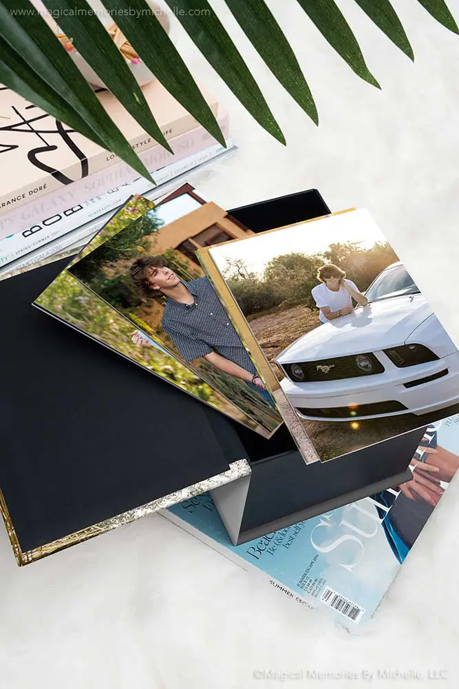 Professional senior photos in a black image box with gold trim displayed on magazines.